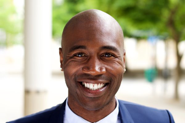 smiling-african-businessman-standing-outdoors-PPMTLXR.jpg